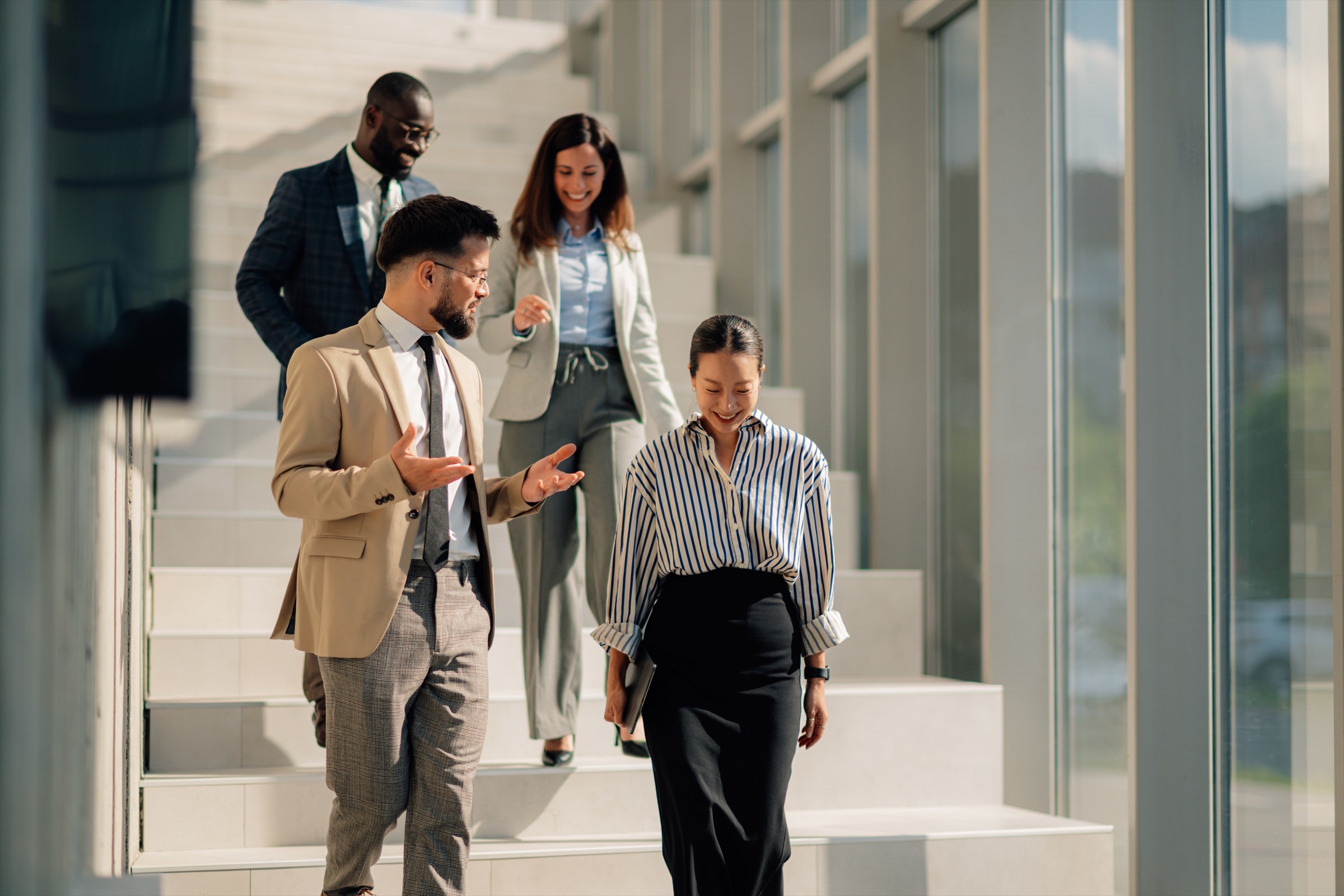 Colleagues walking together through a bright office