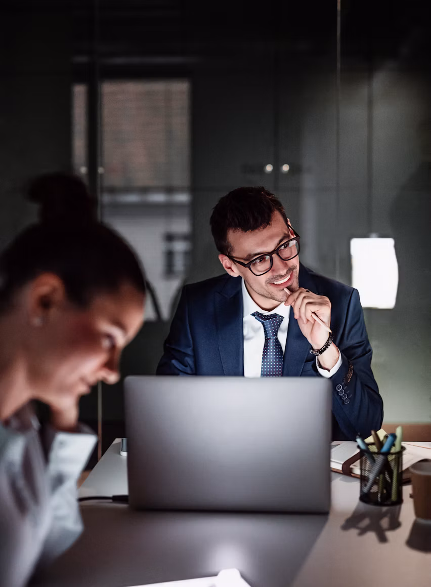 Colleagues discussing work around a laptop in an office