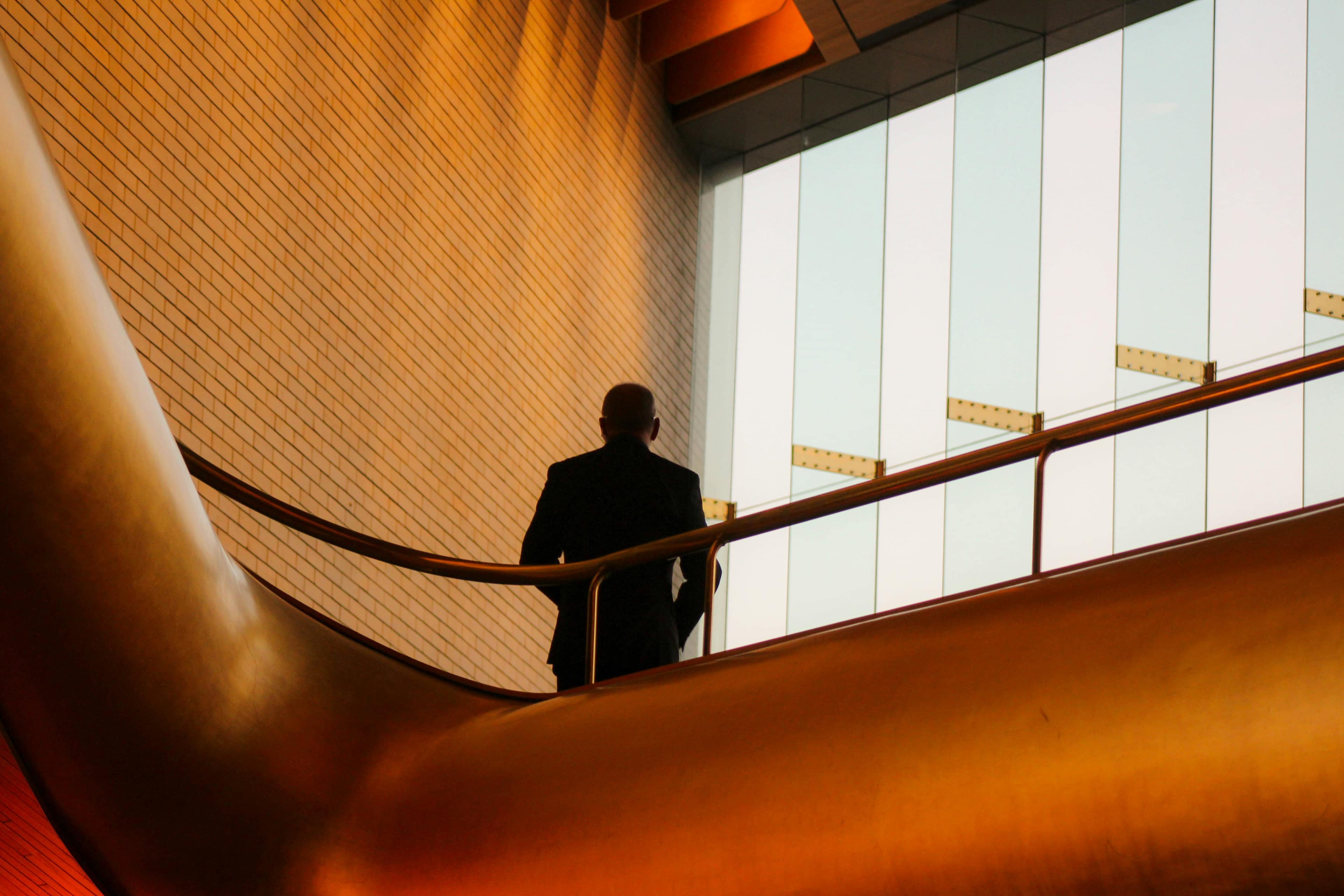 Professional walking through a modern building with warm curved architecture